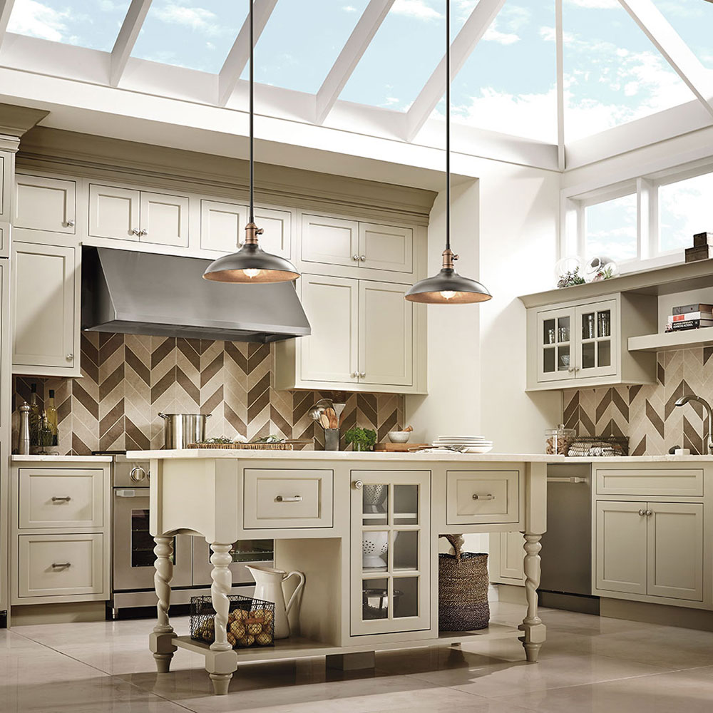 Kitchen with Traditional elements has rustic Kichler Natural Brass Pendants. The sky light adds so much light!