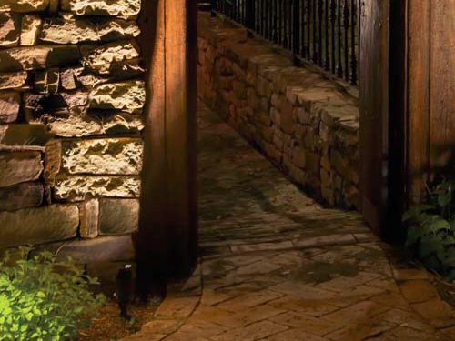 Landscape accent lights graze the stone wall. The shroud keeps any backwash from the light out of our eyes. - Landscape Lighting Beam Spread and Light Control: Light where you want it