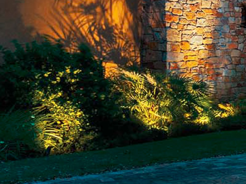 Kichler landscape lights remain invisible, just the landscaping is highlighted with the shadow of the plantings on the wall. - Landscape Lighting Beam Spread and Light Control: Light where you want it