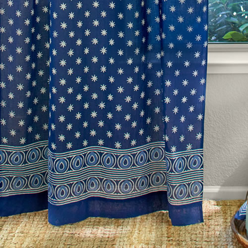 Saffron Marigold Starry Nights: A stunning batik print with a striking off-white star like patterning grounded in deep indigo blue.