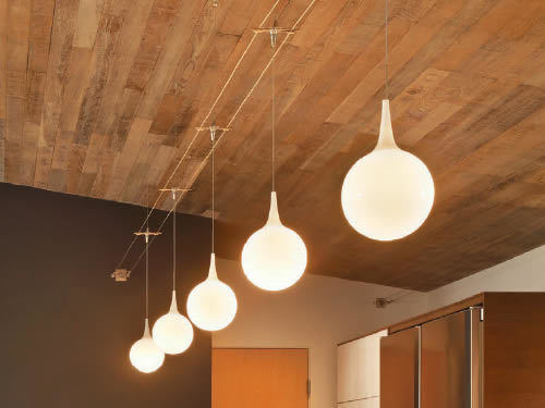 Tech Lighting Pele pendants suspended from Tech Lighting Kable run wall to wall below an exposed wood ceiling Lightweight pendants can be suspended from cable using the free-jack connector.