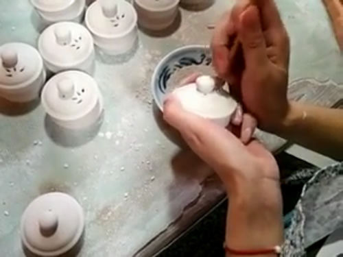 Jingdezhen artisan hand piercing the china before it is fired
