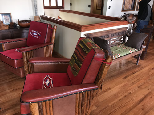 This looks like a Marc Taggart club chairs with red wool Chimayo weavings on the cushions, leather and nail heads at the Auction Preview at Indian Cave Lodge