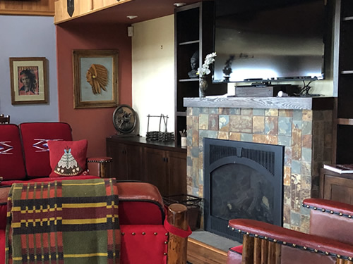 Fireplace, cowboy furniture and framed Indian pictures