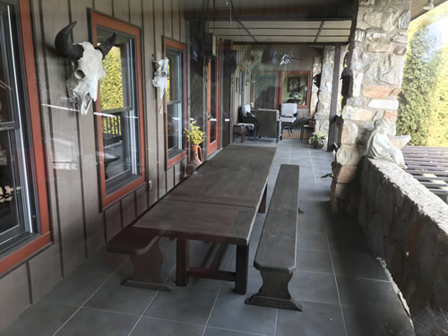 The porches at Indian Cave Lodge with a trestle table and cow skulls on the wall